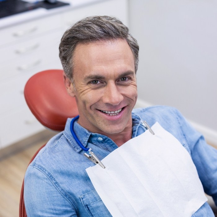 Man smiling in dental chair of Plattsburgh dental office