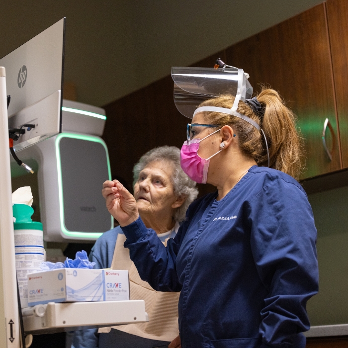 Plattsburgh dental team member showing a screen to a patient