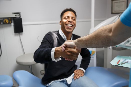 MPatient with dental crowns in Plattsburgh shaking hands with dentist