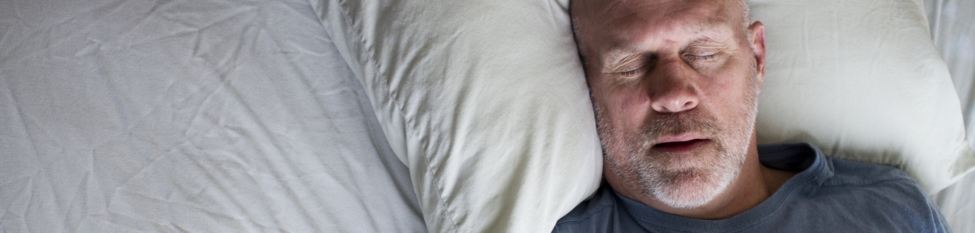 Man sleeping on his back after sleep apnea treatment in Plattsburgh